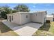 Rear view of gray house with concrete patio at 1404 Torrey Pines Dr, The Villages, FL 32159