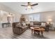 Spacious living room with brown couches, coffee table, and view into kitchen at 1404 Torrey Pines Dr, The Villages, FL 32159
