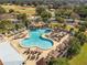 Resort-style pool with waterfall feature and ample lounge space at 1404 Torrey Pines Dr, The Villages, FL 32159