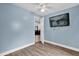 Small bedroom, light blue walls, wood floors, and view of living room at 1412 N Garfield Ave, Deland, FL 32724