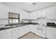 White kitchen with granite countertops and stainless steel appliances at 1412 N Garfield Ave, Deland, FL 32724