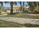 Yellow house with a stone retaining wall and lush landscaping at 163 N Clayton St, Mount Dora, FL 32757