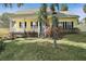 Yellow house with a front porch and well-manicured lawn at 163 N Clayton St, Mount Dora, FL 32757