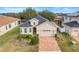 One-story home with a gray roof, red door, and landscaped yard at 16792 Meadows St, Clermont, FL 34714