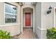Red front door with a brick walkway and arched entryway at 16792 Meadows St, Clermont, FL 34714