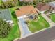 Aerial view of a well-manicured home with a blue driveway, lovely landscaping and lawn at 17412 Se 76Th Flintlock Ter, The Villages, FL 32162