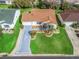 Aerial view of a single-Gathering home with lush green lawn, well-manicured landscaping and a painted driveway with palm tree accents at 17412 Se 76Th Flintlock Ter, The Villages, FL 32162