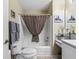 Bathroom featuring a shower-tub combination with neutral tones and a stylish gingham shower curtain at 17412 Se 76Th Flintlock Ter, The Villages, FL 32162