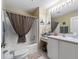 Bathroom featuring a shower-tub combination with neutral tones and a stylish gingham shower curtain at 17412 Se 76Th Flintlock Ter, The Villages, FL 32162