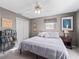 Cozy bedroom featuring a ceiling fan, comfortable bed, and ample storage with a double door closet at 17412 Se 76Th Flintlock Ter, The Villages, FL 32162