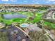 Aerial photo showcases a community clubhouse, swimming pool, and golf course at 17412 Se 76Th Flintlock Ter, The Villages, FL 32162