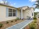 Charming home exterior with neat landscaping, blue shutters, and front patio at 17412 Se 76Th Flintlock Ter, The Villages, FL 32162