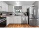 Well-lit kitchen features modern appliances, white cabinetry, and a view of the backyard from the window at 17412 Se 76Th Flintlock Ter, The Villages, FL 32162