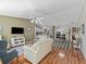 Open-concept living room with hardwood floors, comfortable seating, and seamless flow to the kitchen and dining area at 17412 Se 76Th Flintlock Ter, The Villages, FL 32162