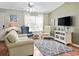 Cozy living room with hardwood floors, comfortable seating, and a television for entertainment at 17412 Se 76Th Flintlock Ter, The Villages, FL 32162