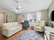 Comfortable living room with hardwood floors, a cozy sofa, and natural light from a large window at 17412 Se 76Th Flintlock Ter, The Villages, FL 32162