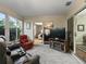 Bright sunroom with comfortable seating, a large TV, and sliding glass doors offering scenic outdoor views at 17412 Se 76Th Flintlock Ter, The Villages, FL 32162