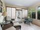 Relaxing sunroom featuring tiled floors, comfortable seating, and large windows offering ample natural light at 17412 Se 76Th Flintlock Ter, The Villages, FL 32162
