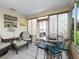 Sunroom offers plenty of natural light and is furnished with comfortable seating and dining options at 17412 Se 76Th Flintlock Ter, The Villages, FL 32162