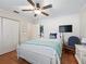 Bright bedroom with a queen-size bed, hardwood floors, and ceiling fan at 17744 Se 95Th Ct, Summerfield, FL 34491