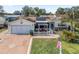 Front view of a single-story house with solar panels, pergola, and a spacious driveway at 17744 Se 95Th Ct, Summerfield, FL 34491