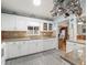 Kitchen boasts white cabinets, granite countertops, and a view into the dining area at 17744 Se 95Th Ct, Summerfield, FL 34491