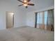 Living room with carpet, window, and access to hallway at 1930 Harston Trl, The Villages, FL 32162