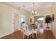 Bright dining room with hardwood floors, glass-top table, and chandelier at 21837 Royal St Georges Ln, Leesburg, FL 34748