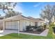 Brick ranch home with screened garage, landscaped yard, and walkway at 21837 Royal St Georges Ln, Leesburg, FL 34748