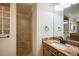 Updated bathroom featuring granite counters, a white sink, and a tiled walk-in shower with convenient built-in seating at 2709 Astoria Ave, The Villages, FL 32162