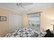 Inviting bedroom features a ceiling fan, double closet doors, a large window, and a comfortable queen-sized bed at 2709 Astoria Ave, The Villages, FL 32162