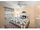 Comfortable bedroom features a ceiling fan, a large window with a view, crown moulding and neutral colored walls at 2709 Astoria Ave, The Villages, FL 32162