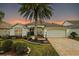 Charming single-story home with a large palm tree, manicured lawn, and paver driveway at 2709 Astoria Ave, The Villages, FL 32162