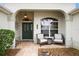 Inviting front porch featuring seating, decorative door with glass, and charming accents at 2709 Astoria Ave, The Villages, FL 32162
