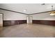 Large basement with wainscoting, neutral walls, tile flooring, and access to other rooms at 29319 Old Mill E, Tavares, FL 32778