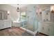 Bright bathroom featuring double vanities, a soaking tub and glass enclosed shower with marble-look tile surround at 29319 Old Mill E, Tavares, FL 32778