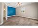Open primary bedroom with blue accent wall, light hardwood floors, and shutters with ensuite bathroom at 29319 Old Mill E, Tavares, FL 32778