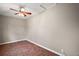 Cozy room with ceiling fan and red-toned flooring at 29319 Old Mill E, Tavares, FL 32778