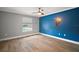 Spacious bedroom with wood-look floors and a blue accent wall at 29319 Old Mill E, Tavares, FL 32778