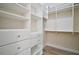Organized walk-in closet featuring white shelving and drawers, and wood look floors at 29319 Old Mill E, Tavares, FL 32778