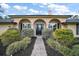 Charming single-story home with a stone walkway, manicured bushes, and a stylish front door at 29319 Old Mill E, Tavares, FL 32778
