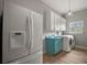 Bright laundry room features a blue sink vanity, white washer/dryer, upper cabinets, and wood-look vinyl flooring at 29319 Old Mill E, Tavares, FL 32778