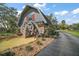 Unique building featuring a charming water mill, stone accents, and a quaint design, set beside a pond at 29319 Old Mill E, Tavares, FL 32778