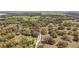 Scenic aerial view of the property, highlighting the wooded acreage with a long driveway at 3380 Cr 528, Sumterville, FL 33585
