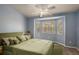 Bedroom featuring a bay window, fan and light, and neutral blue paint at 3380 Cr 528, Sumterville, FL 33585