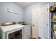 Neat laundry room features modern washer and dryer units, storage shelving and white door at 3380 Cr 528, Sumterville, FL 33585