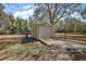 Exterior view of a backyard shed with a roll-up door and wooden ramp at 3380 Cr 528, Sumterville, FL 33585