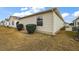 Tan vinyl-sided home with small window and manicured landscaping at 3764 Ivey Ter, The Villages, FL 32163