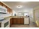 Open kitchen with island, white appliances, and wood cabinets at 3764 Ivey Ter, The Villages, FL 32163