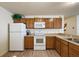 White appliances and wood cabinets highlight this kitchen at 3764 Ivey Ter, The Villages, FL 32163